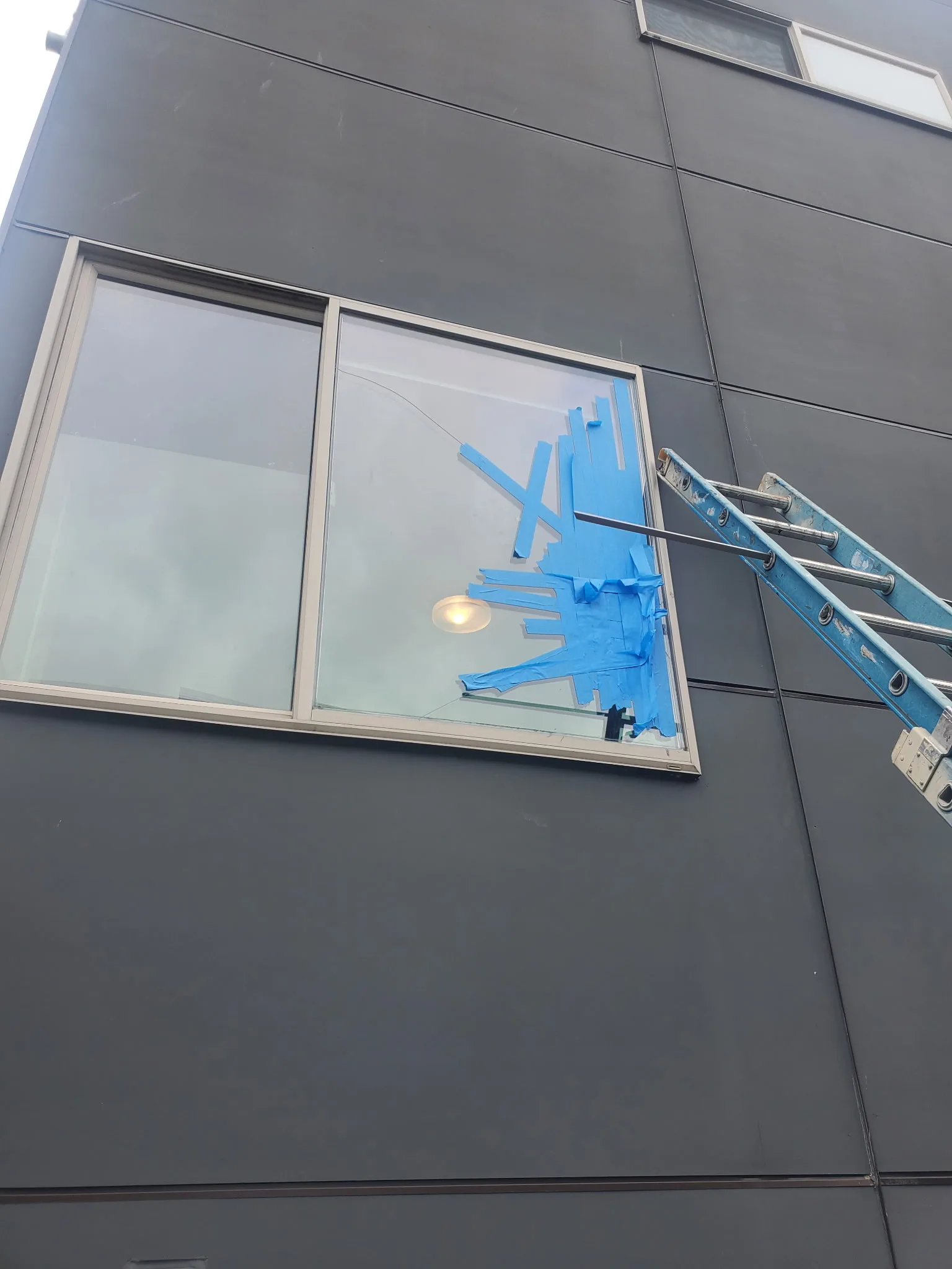 Commercial glass panel replacement in progress on a modern storefront facade