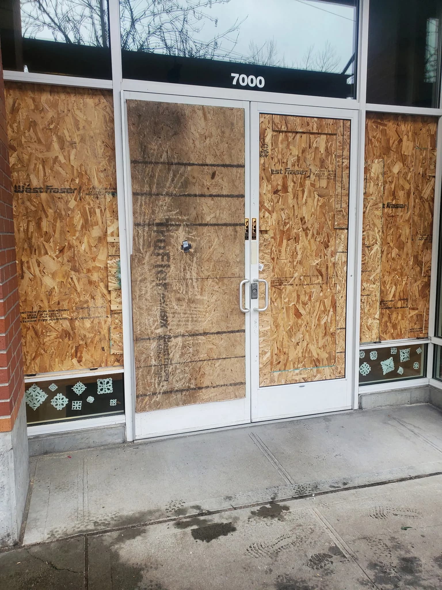Street-facing storefront secured with same-day emergency board-up panels